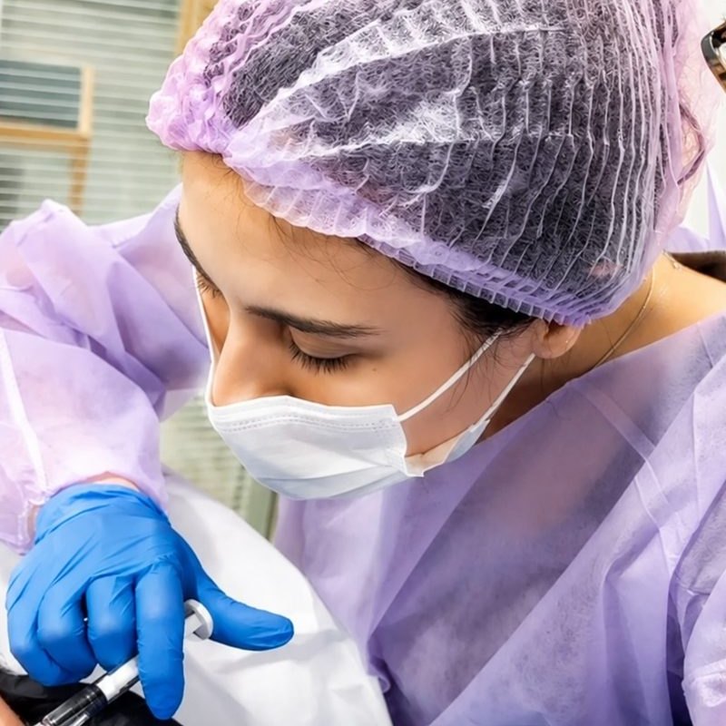 Dra. Roberta Sayuri, médica (CRM-SP 213495), durante procedimento, com paramentação completa